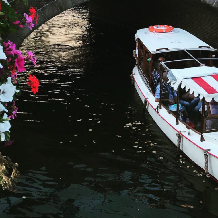 The boat under a bridge on a canal in Amsterdam